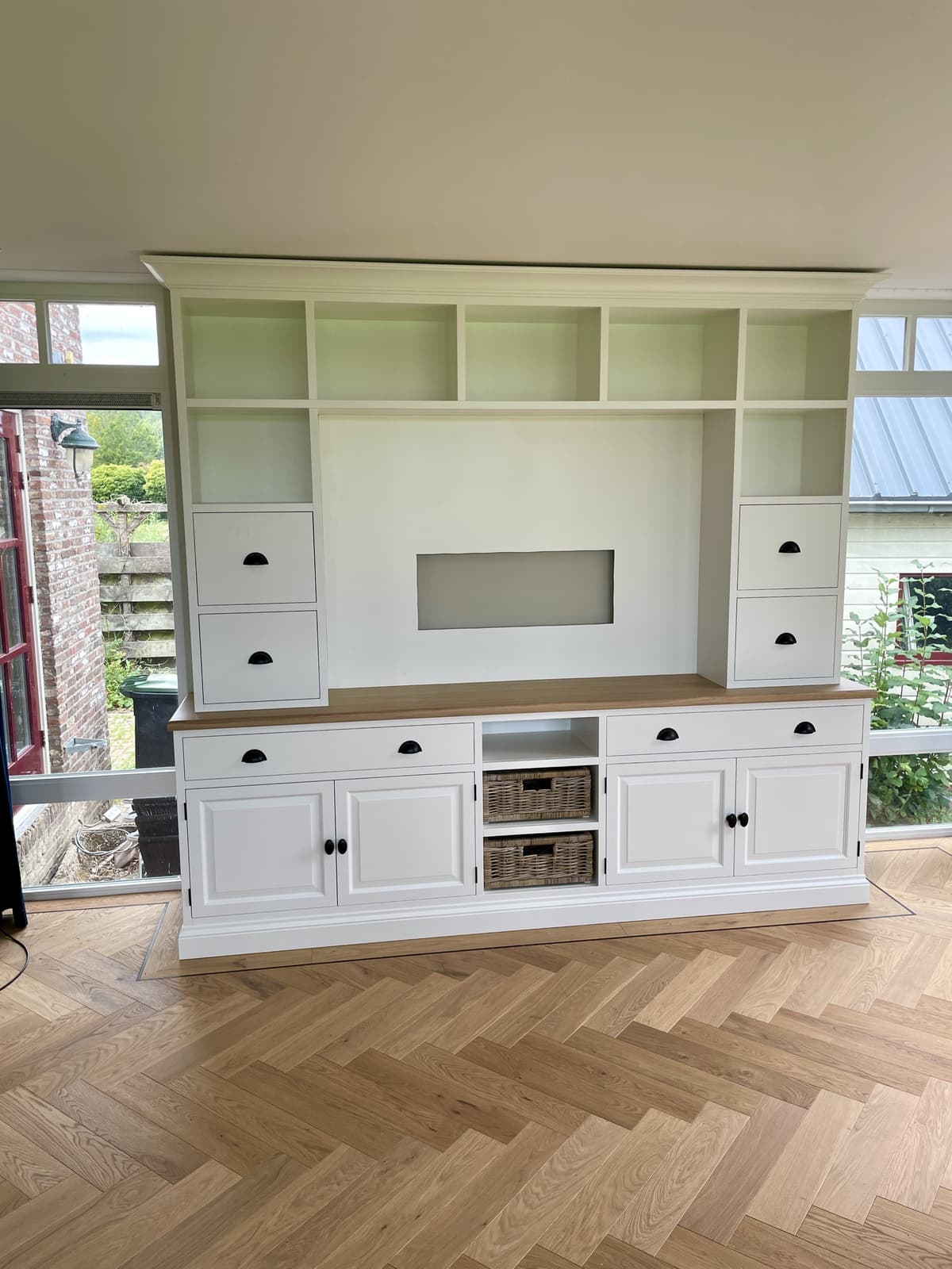 Op maat gemaakte wandkast met rieten manden in het atelier van Ans Woonshop